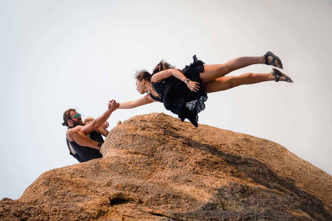 girl holding on as falling off cliff in California desert