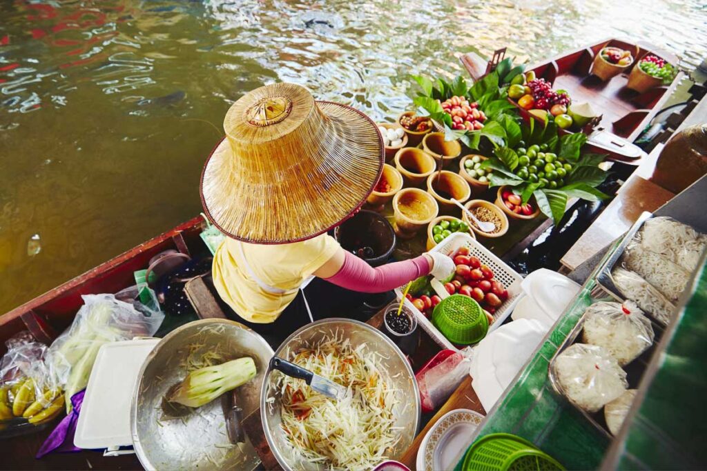 floating market vendor selling fruits and vegetables