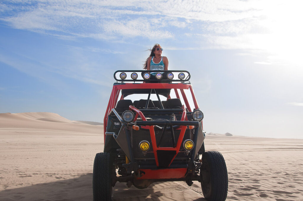 catherine xu sitting on top of dune buggy in peru