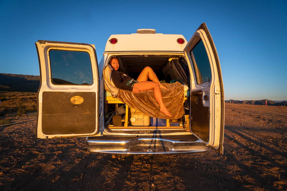 Nomadicated sitting in the back of van during the sunset