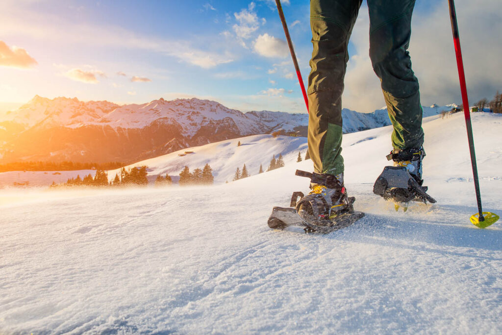 Detail of man walking with technical snowshoes in mountains on a grand teton winter tour