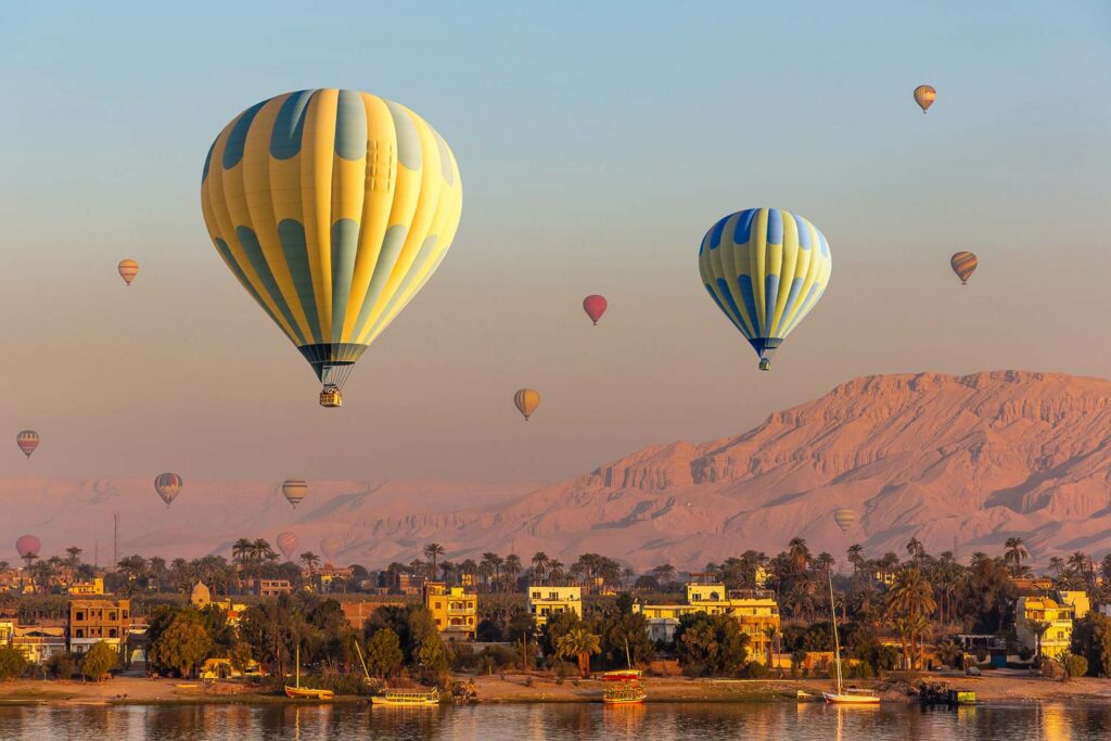 Hot air balloons over Nile river and Valley of Kings in Luxor at sunrise in Egypt