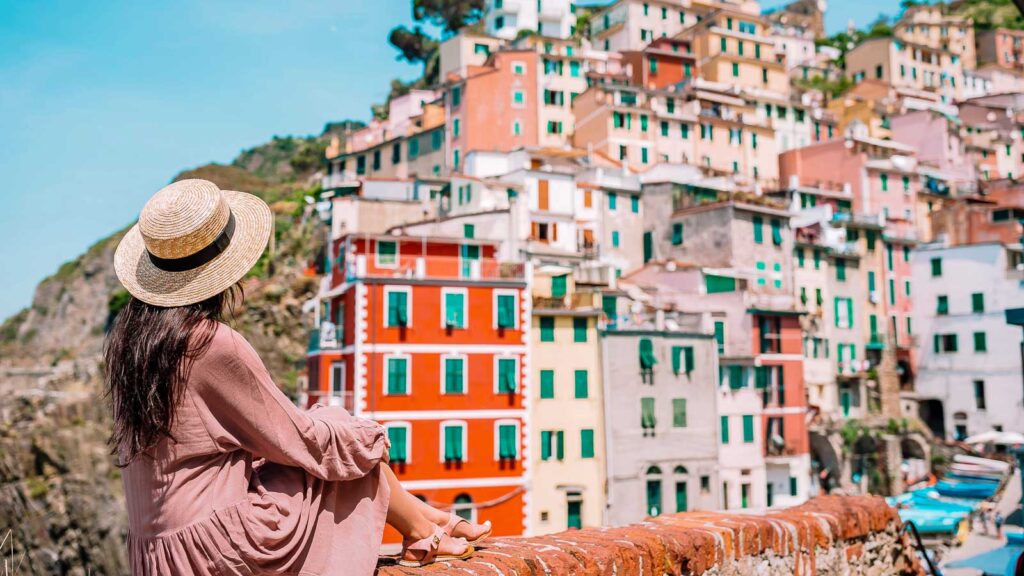 Italy, Young woman with great view at old village Riomaggiore Cinque Terre