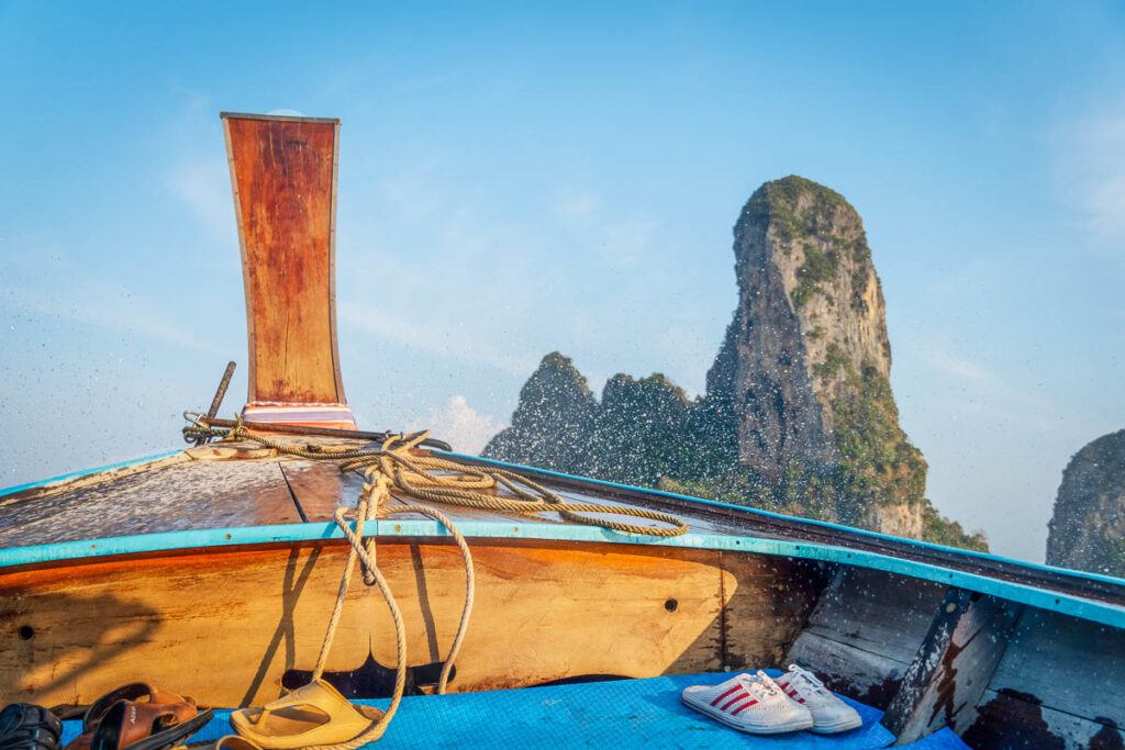 long-tail boat service in fron tof limestone cliffs