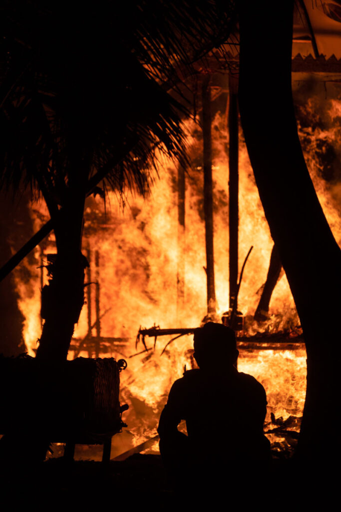 silhouette of man in front of cremation fire