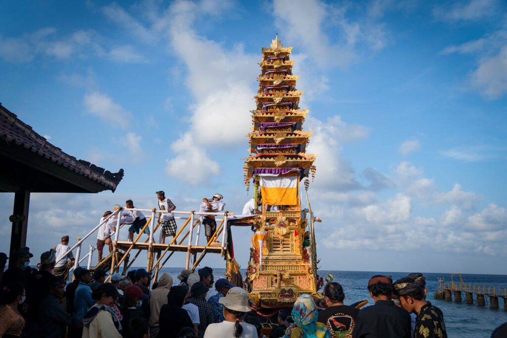 man placing the skeleton remains into the wadah for ngaben