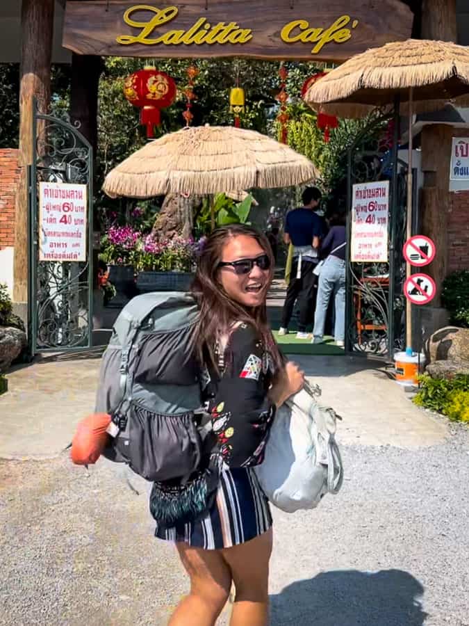 Cat walking into a Thailand Cafe with a backpack